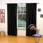 Black velvet rod pocket curtains hung at a window