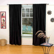 Black velvet rod pocket curtains hung at a window