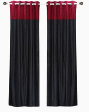 Burgundy velvet ring top curtains hung at a window