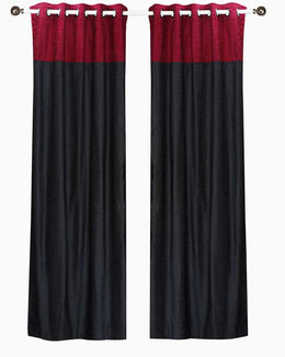 Burgundy velvet ring top curtains hung at a window