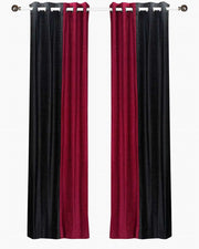 Burgundy velvet ring top curtains hung at a window