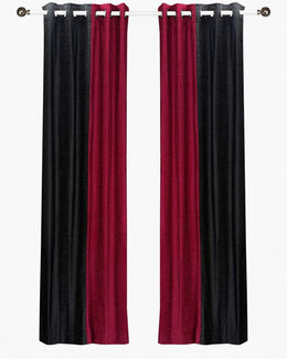 Burgundy velvet ring top curtains hung at a window