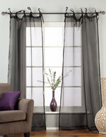 Black sheer tissue tie top curtains hung at a window
