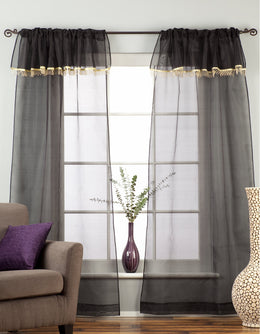Black sheer tissue rod pocket curtains hung at a window