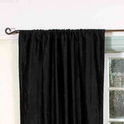 Black velvet rod pocket curtains hung at a window