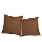 Brown with gold trim raw silk cushion covers arranged on a sofa
