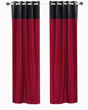 Burgundy velvet ring top curtains hung at a window