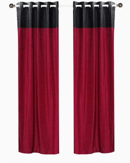 Burgundy velvet ring top curtains hung at a window