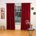 Burgundy velvet rod pocket curtains hung at a window
