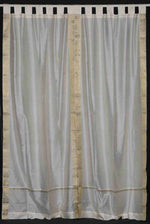 Cream sari tab top curtains hung at a window