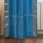 Turquoise sari rod pocket curtains hung at a window