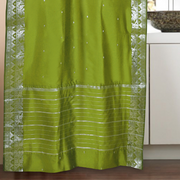 Olive green sari rod pocket curtains hung at a window