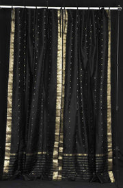 Black sari tie top curtains hung at a window