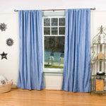 Caribbean blue velvet rod pocket curtains hung at a window