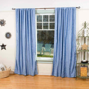 Light blue velvet rod pocket curtains hung at a window