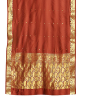 Rust sari rod pocket curtains hung at a window