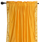 Yellow sari rod pocket curtains hung at a window