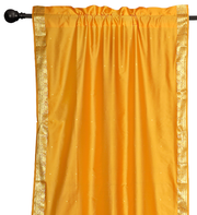 Yellow sari rod pocket curtains hung at a window