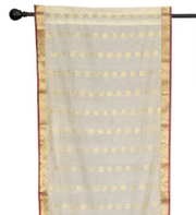 Cream sari rod pocket curtains hung at a window