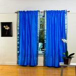 Blue sari rod pocket curtains hung at a window