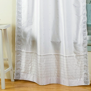 Silver sari rod pocket curtains hung at a window