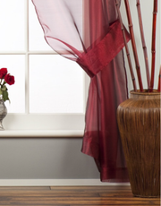 Maroon sheer tissue rod pocket curtains hung at a window