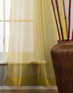 Gold sheer tissue rod pocket curtains hung at a window