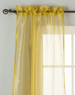Gold sheer tissue rod pocket curtains hung at a window
