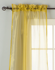 Gold sheer tissue rod pocket curtains hung at a window