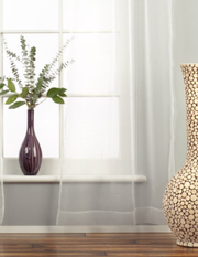 White sheer tissue rod pocket curtains hung at a window