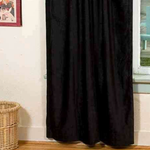 Black velvet rod pocket curtains hung at a window