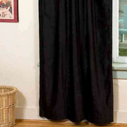 Black velvet rod pocket curtains hung at a window
