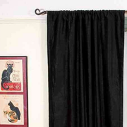 Black velvet rod pocket curtains hung at a window