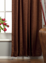 Brown velvet rod pocket curtains hung at a window