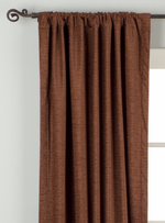 Brown velvet rod pocket curtains hung at a window