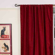 Burgundy velvet rod pocket curtains hung at a window
