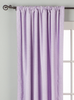 Lavender velvet rod pocket curtains hung at a window