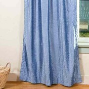 Light blue velvet rod pocket curtains hung at a window