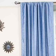 Light blue velvet rod pocket curtains hung at a window
