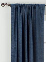 Navy blue velvet rod pocket curtains hung at a window