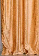 Peach velvet rod pocket curtains hung at a window