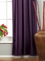 Purple velvet rod pocket curtains hung at a window