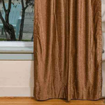 Taupe velvet rod pocket curtains hung at a window