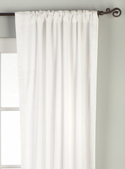 White velvet rod pocket curtains hung at a window