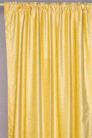 Yellow velvet rod pocket curtains hung at a window