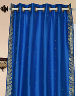 Blue sari grommet top curtains hung at a window