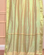 Golden sari grommet top curtains hung at a window