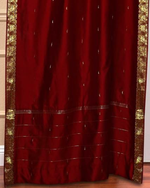 Maroon sari grommet top curtains hung at a window