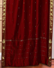 Maroon sari grommet top curtains hung at a window