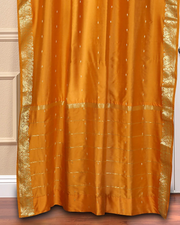 Mustard sari grommet top curtains hung at a window